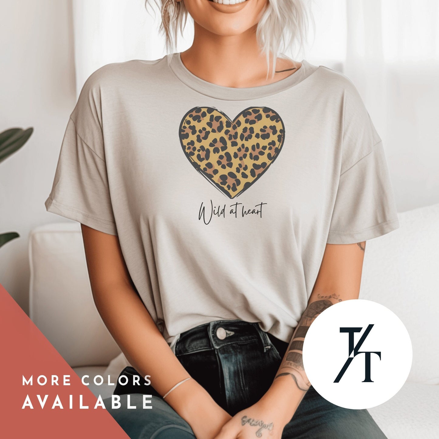 a woman sitting on a couch wearing a leopard print heart t - shirt