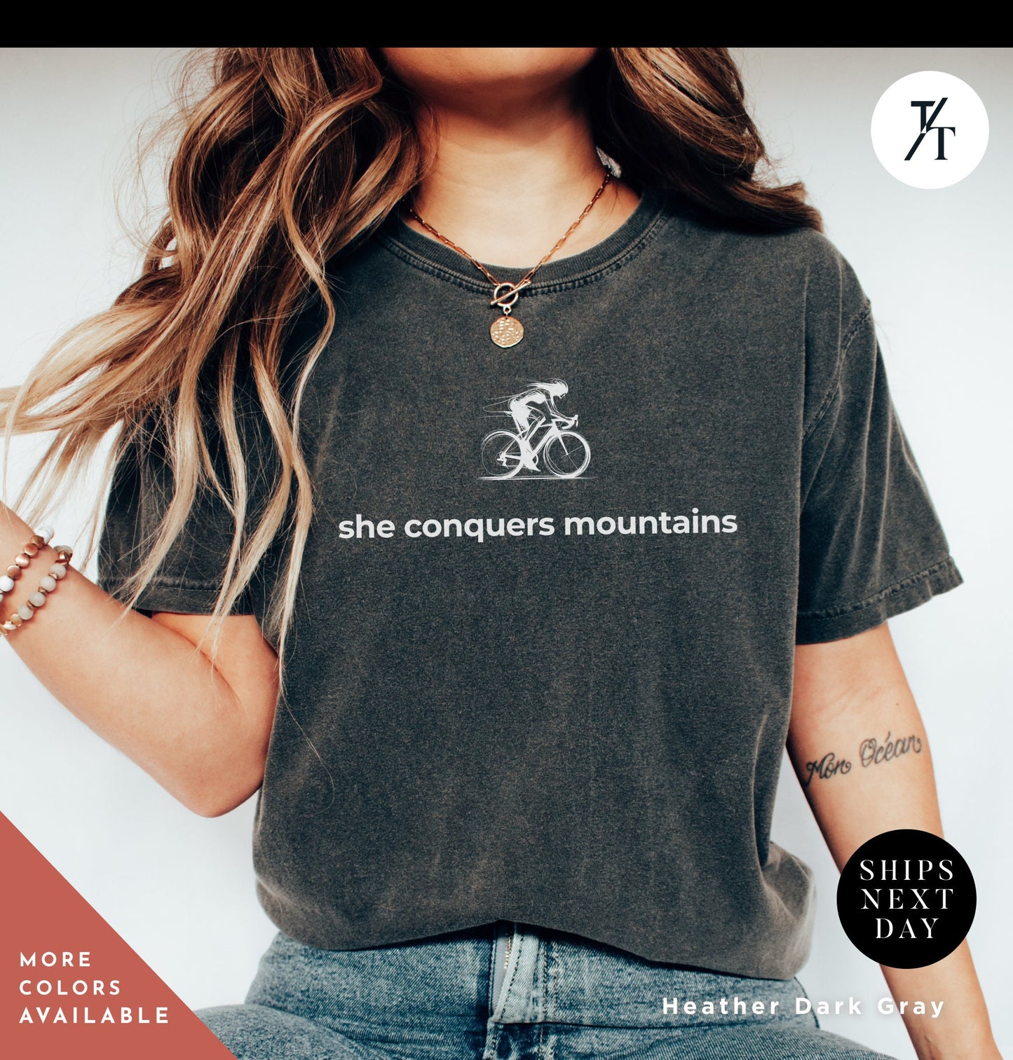 a woman wearing a shirt that says she conquers mountains