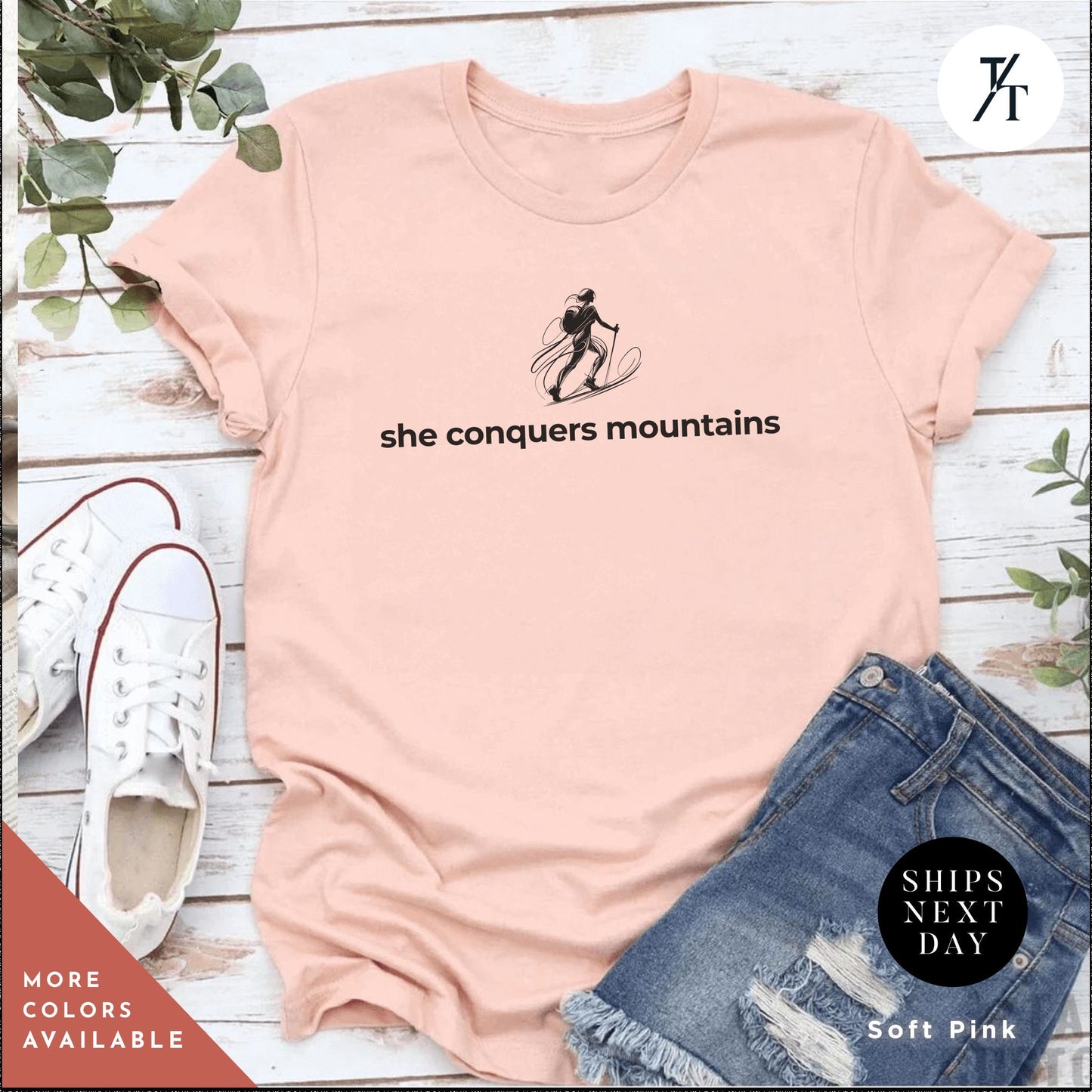 a pink shirt with the words she conquers mountains on it