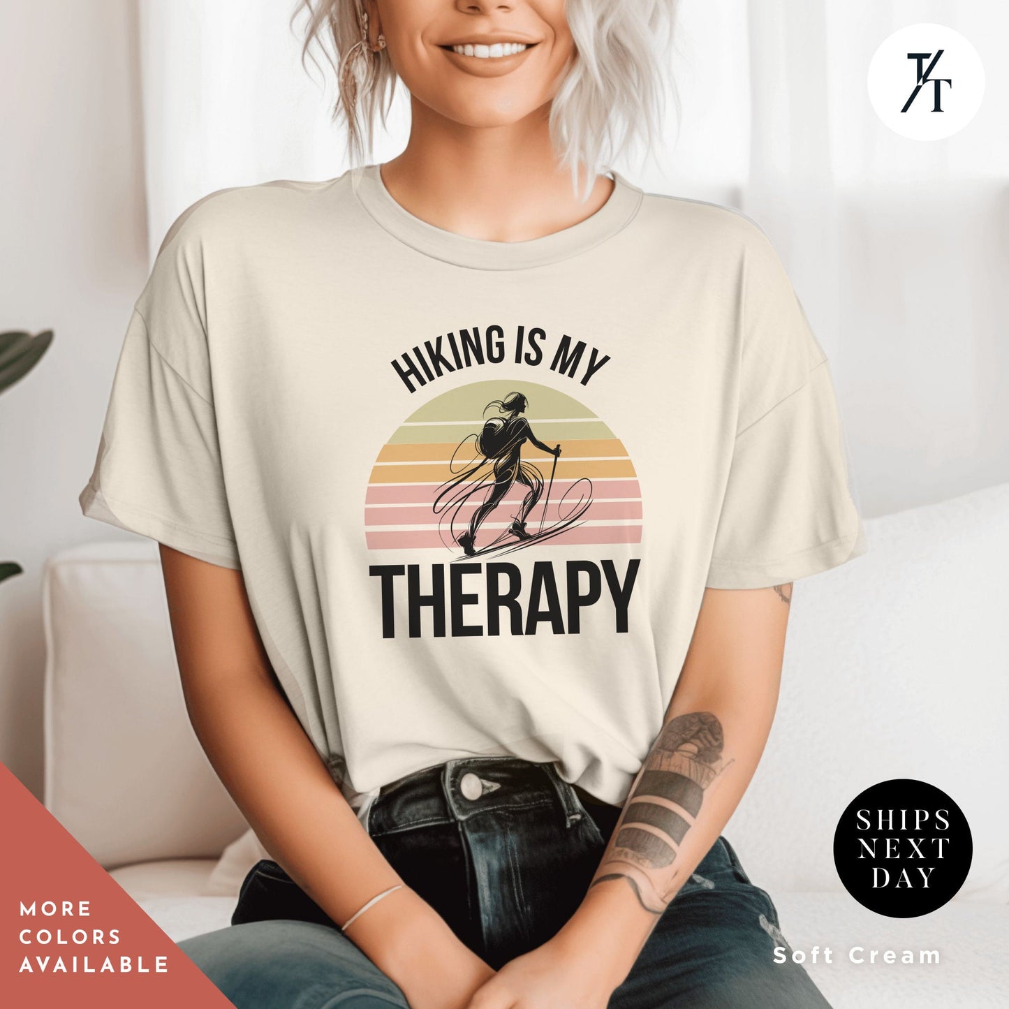 a woman sitting on a couch wearing a shirt that says hiking is my therapy