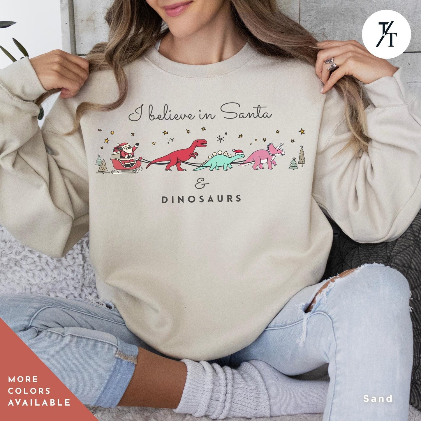 a woman sitting on a couch wearing a sweatshirt that says believe in santa and dinosaurs, I believe in santa and dinosaurs sweatshirt, Christmas Sweatshirt, I Believe In Santa Dinosaurs Sweatshirts, Christmas Gifts Holiday Sweater