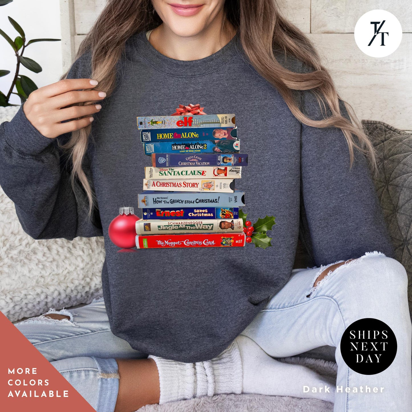 a woman sitting on a couch holding a stack of VHS tapes on it, Vintage christmas vhs sweatshirt, Christmas Sweatshirt, Holiday Crewneck, Vhs Movies Sweater, Gift For Her, Retro Xmas Video Cassette Tapes