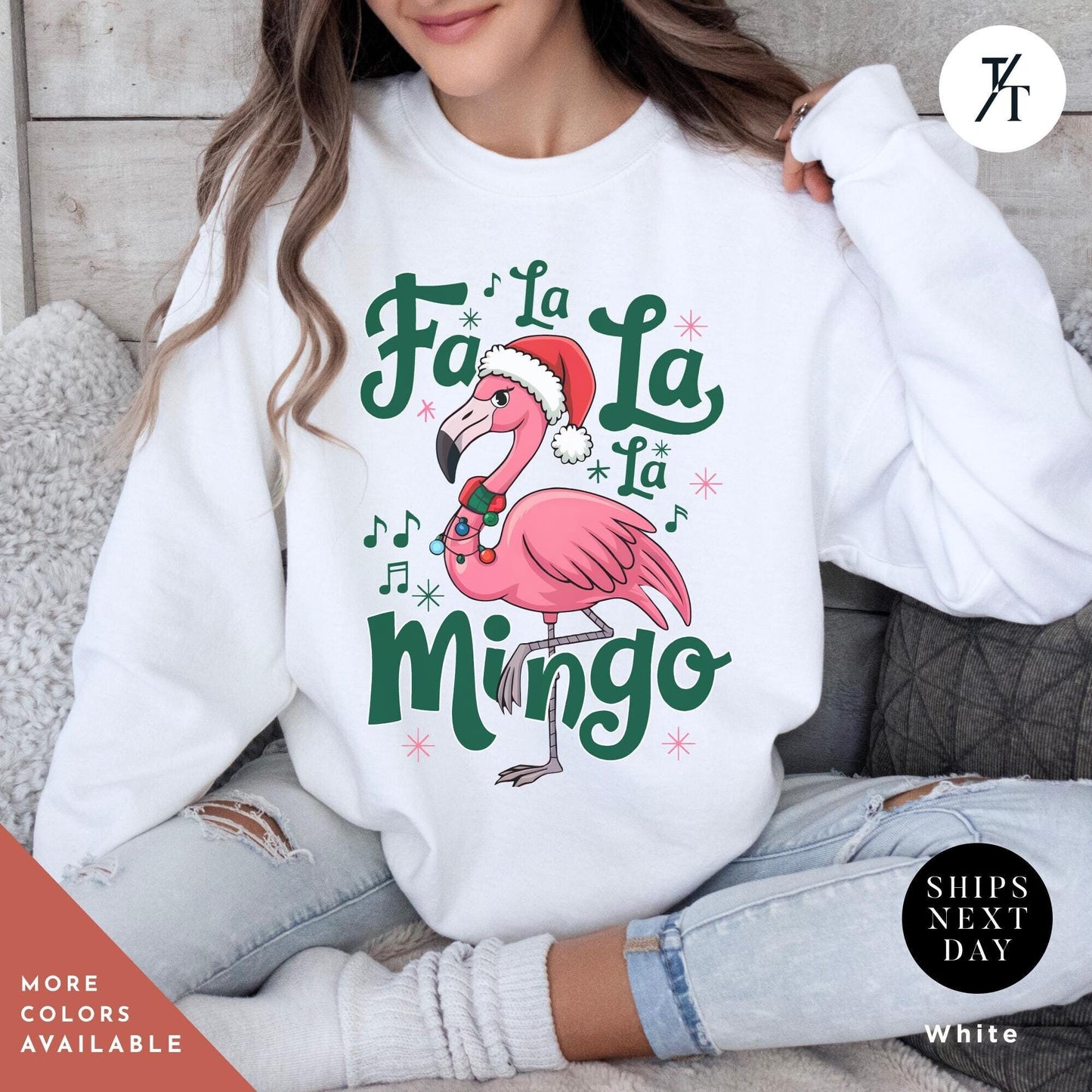a woman sitting on a couch wearing a white sweatshirt with a pink flamingo wearing Christmas Flamingo Sweatshirt, Fa La La Mingo Tropical Christmas Sweater, Flamingo Xmas Shirt Flamingos Lover Gift, Cute Santa Hat Flamingos
