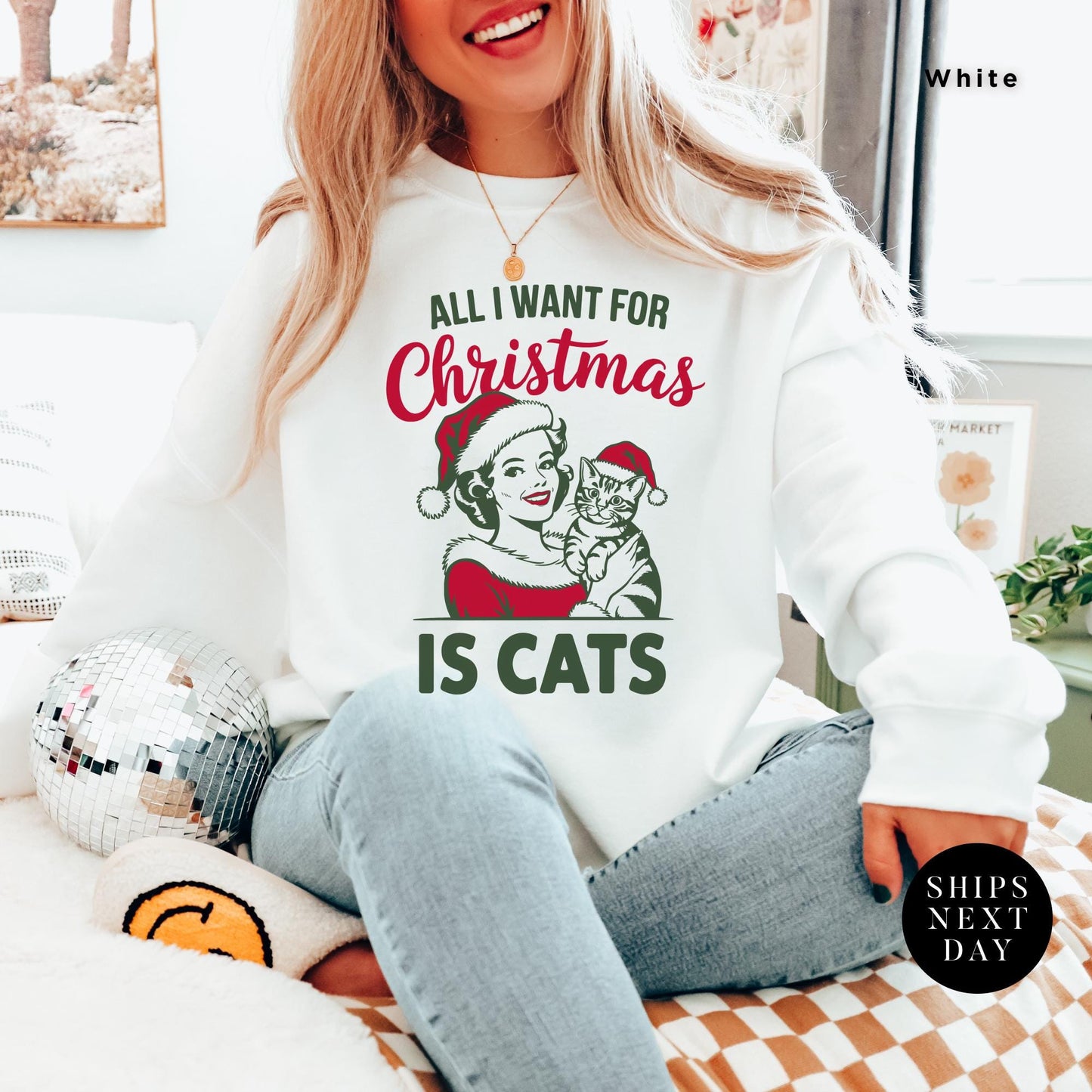 a woman sitting on top of a bed wearing a sweatshirt, all i want for christmas is cats Retro Christmas Sweatshirt, Retro Cat All I Want For Xmas Sweater, Gift For Cat Lover, Holiday Sweatshirt