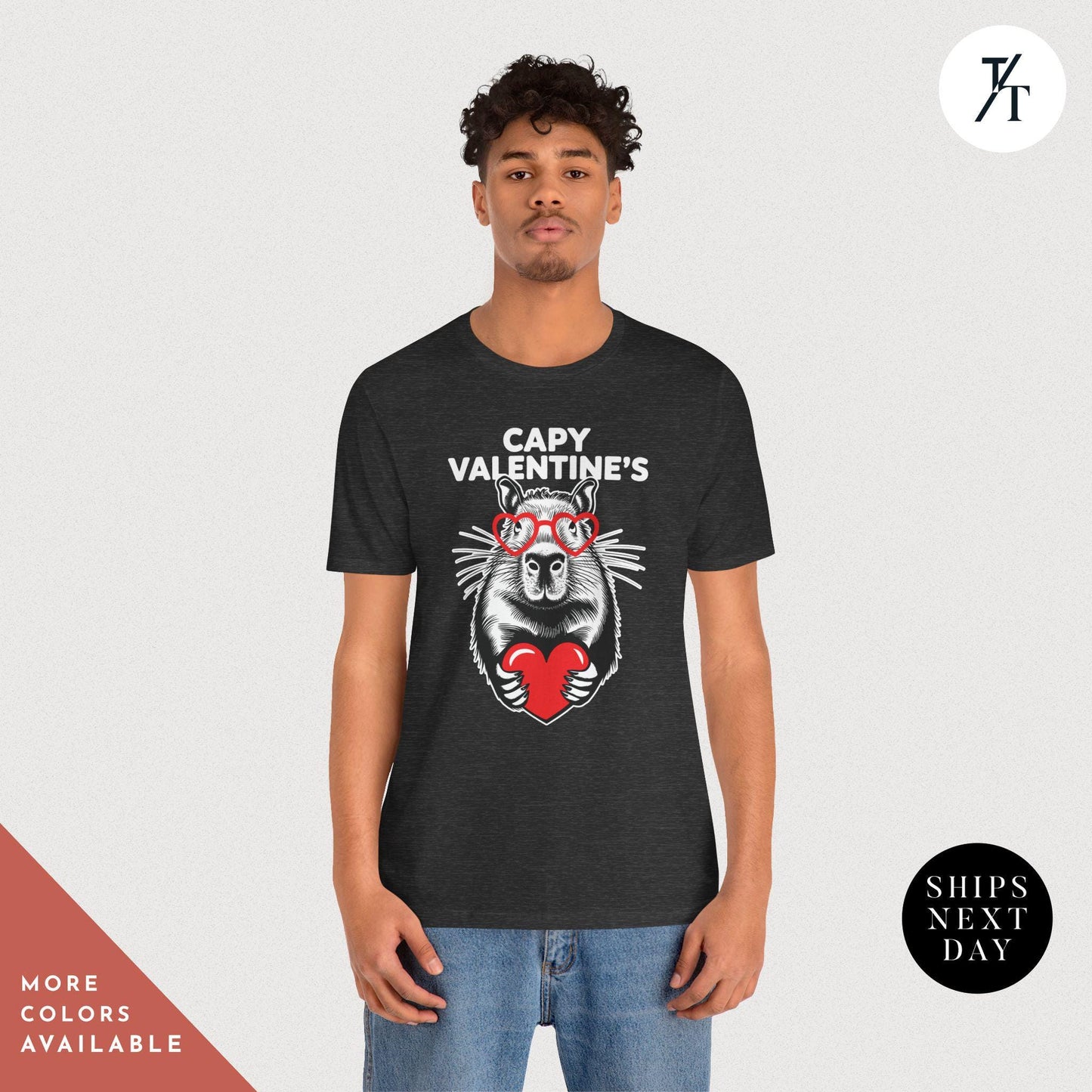 a man wearing a dark grey t - shirt with an image of a capybara holding a heart that says Capy Valentines, Capybara Valentines Shirt, Gift For Her, Capybara Lover Gift, Funny Capybaras Shirt, Valentines Day Gifts, Animal Lover Gifts, Capybaras tee