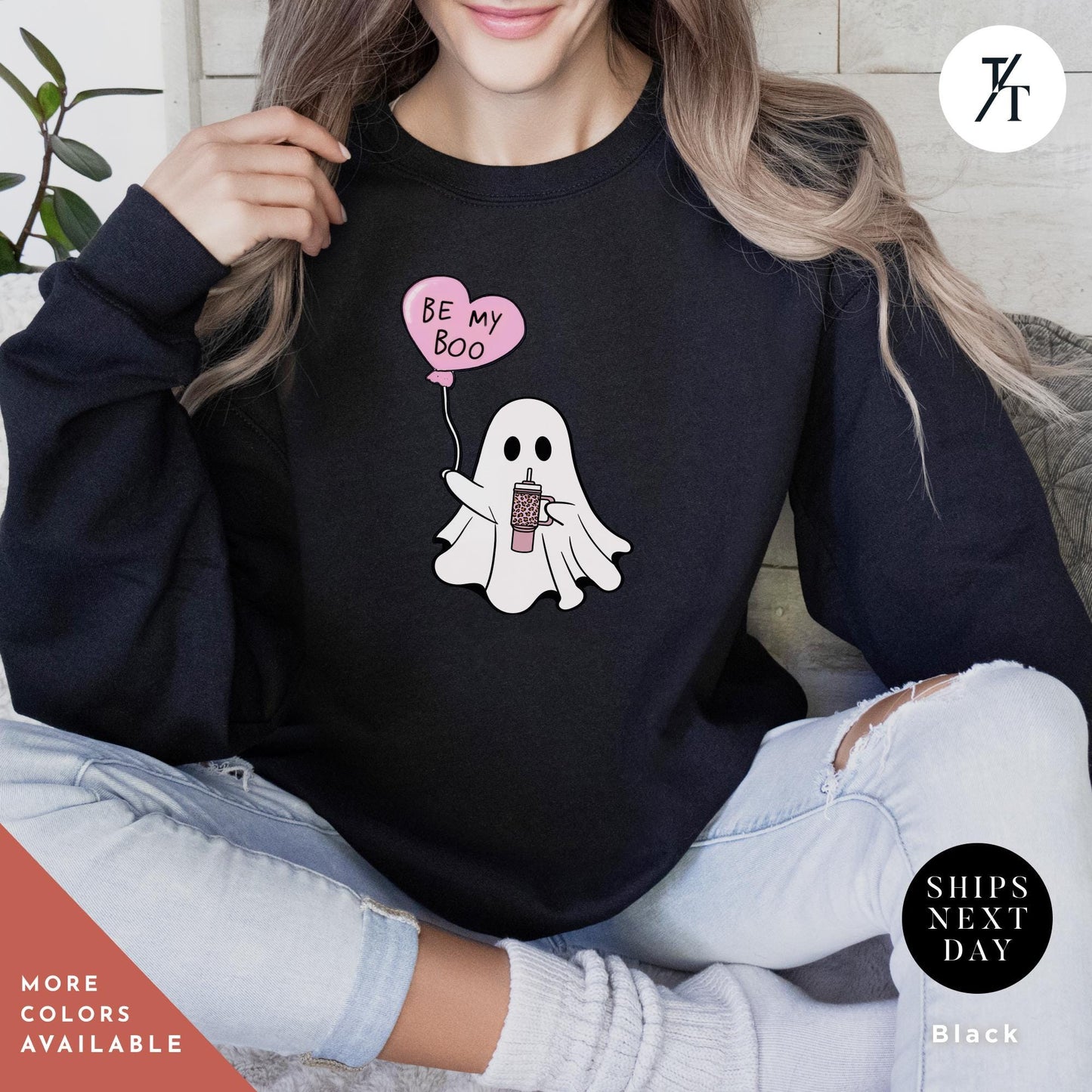 a woman wearing a sweatshirt with a ghost holding a heart balloon