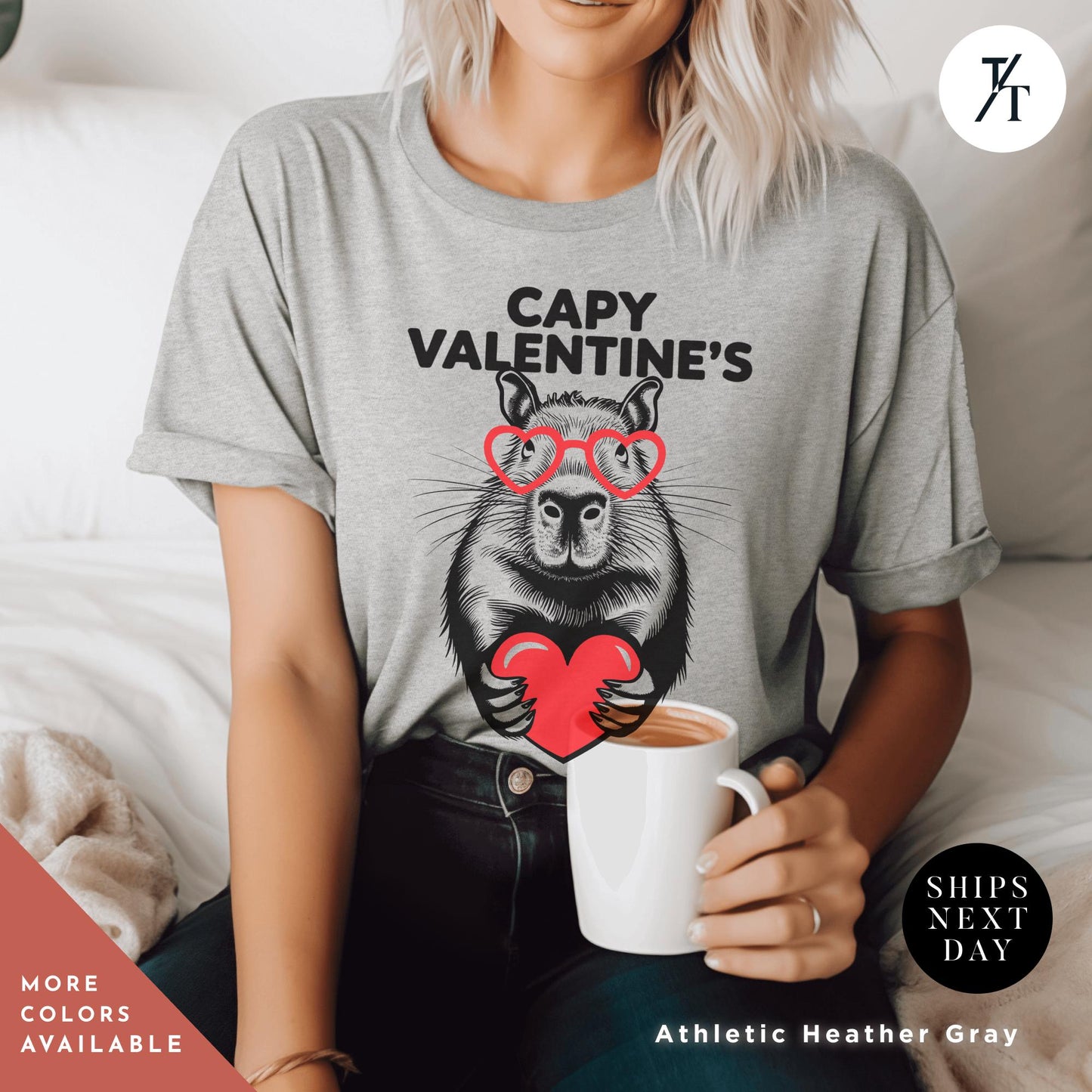 a woman wearing grey a t - shirt with an image of a capybara holding a heart that says Capy Valentines, Capybara Valentines Shirt, Gift For Her, Capybara Lover Gift, Funny Capybaras Shirt, Valentines Day Gifts, Animal Lover Gifts, Capybaras tee