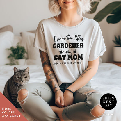a woman sitting on a bed with a cat and a shirt that says a t - shirt that says i have two titles gardener and cat mom and i am rockin&#39; them both
