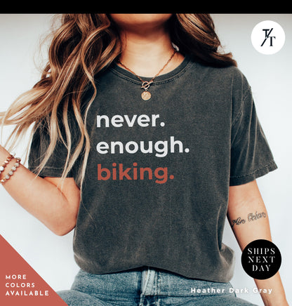 a woman wearing a shirt that says never enough biking