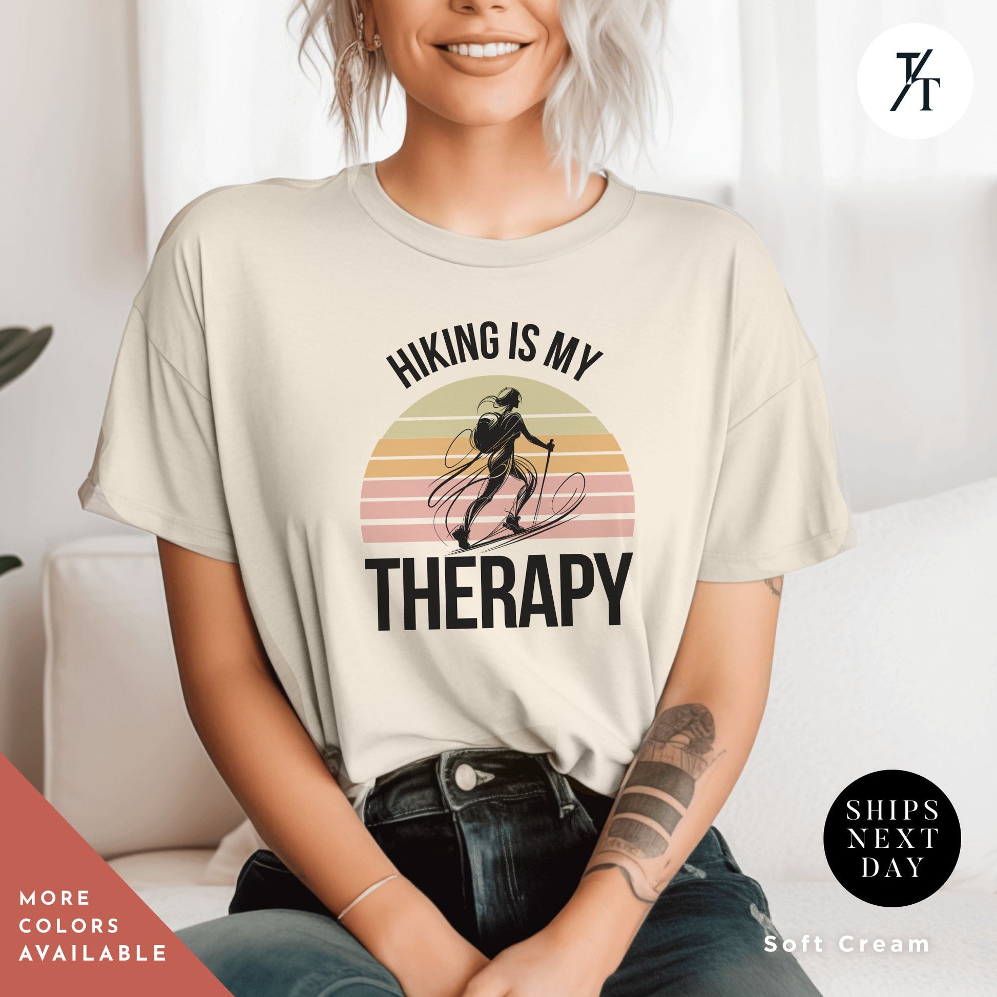 a woman sitting on a couch wearing a shirt that says hiking is my therapy