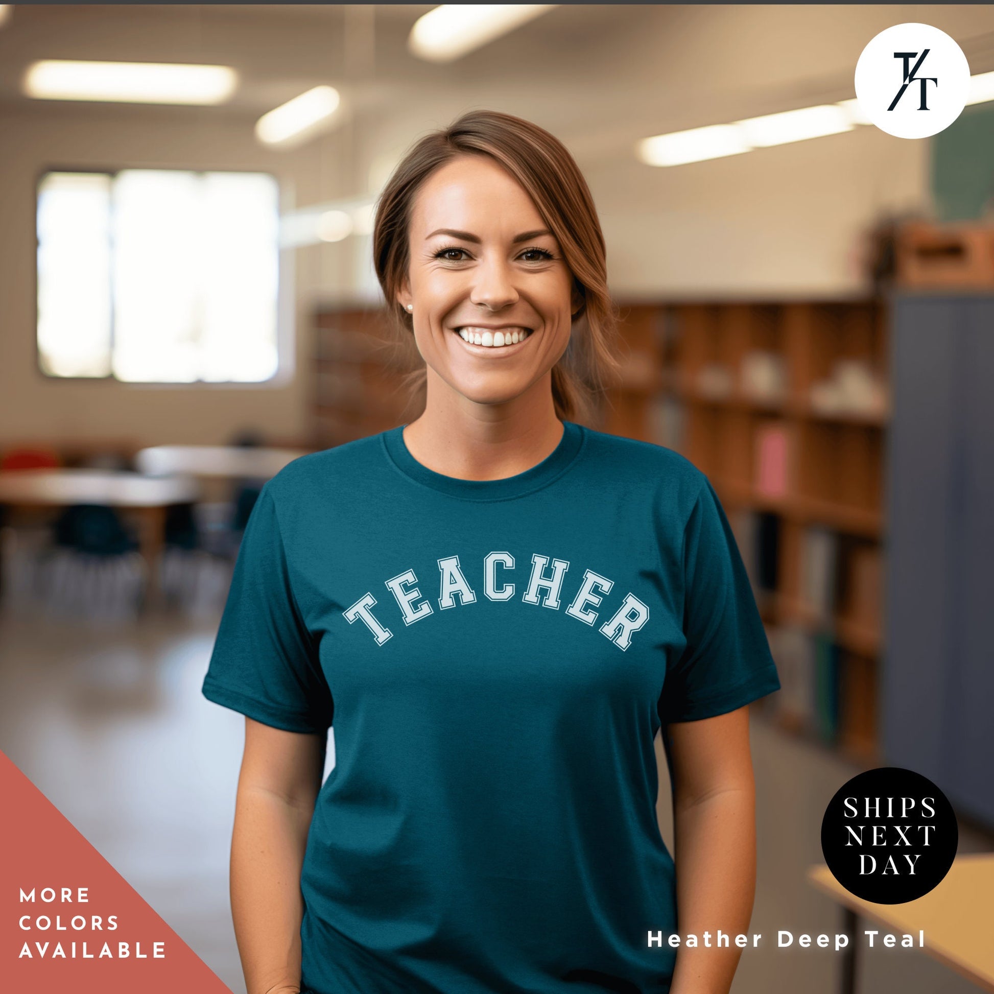 a smiling woman wearing a teacher shirt in a library