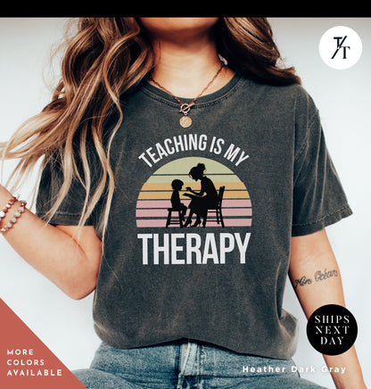 a woman wearing a shirt that says teaching is my therapy