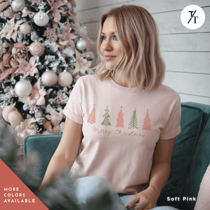 a woman sitting on a couch in front of a christmas tree, a shirt with 4 pink Christmas trees that says &quot;Merry Christmas&quot; North Pole Christmas Tree Farm Shirt, Coquette Pink Christmas Tree Shirt, Xmas Gift, Farm Fresh Xmas Shirt, Women Holiday Tee