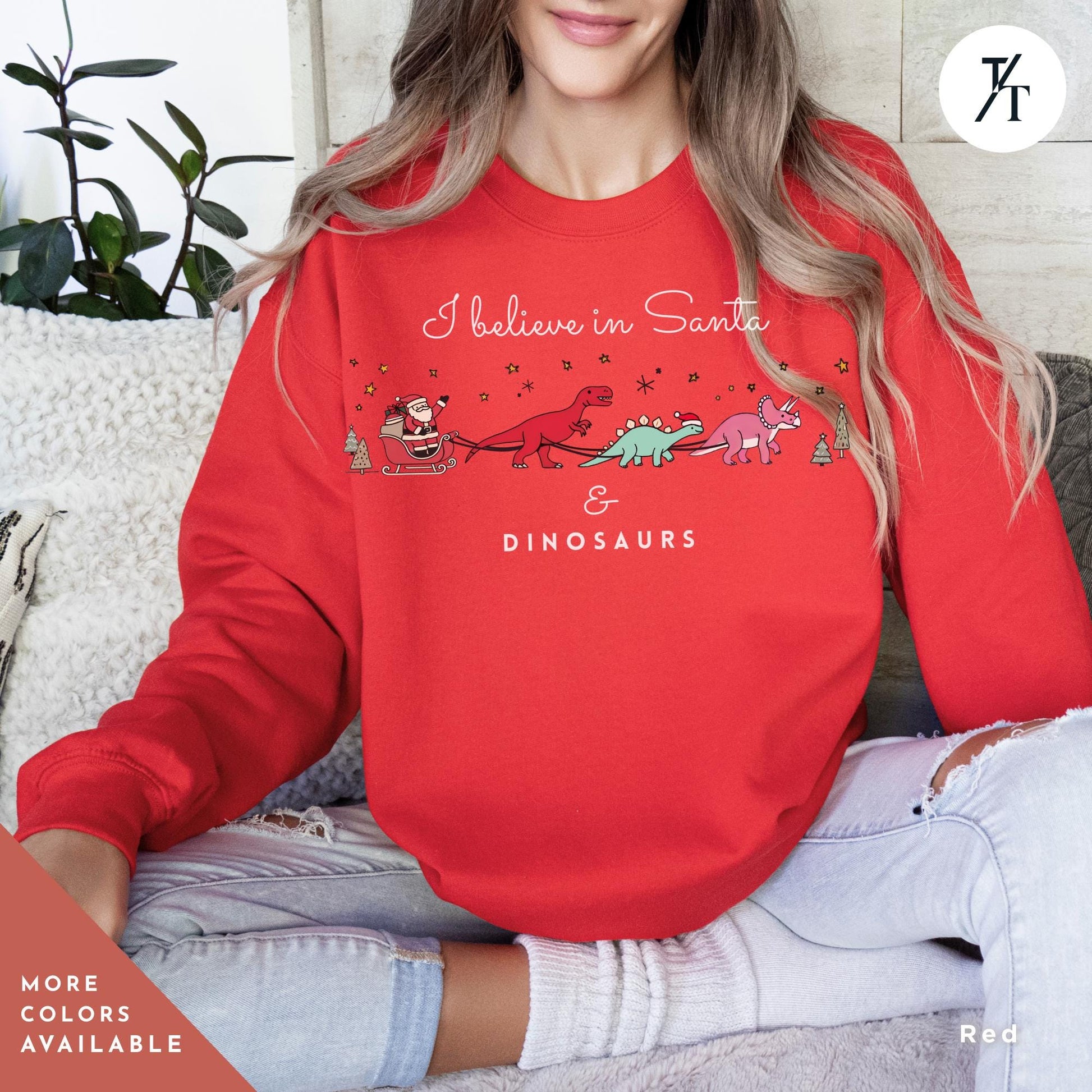 a woman sitting on a couch wearing a red sweatshirt, I believe in santa and dinosaurs sweatshirt, Christmas Sweatshirt, I Believe In Santa Dinosaurs Sweatshirts, Christmas Gifts Holiday Sweater
