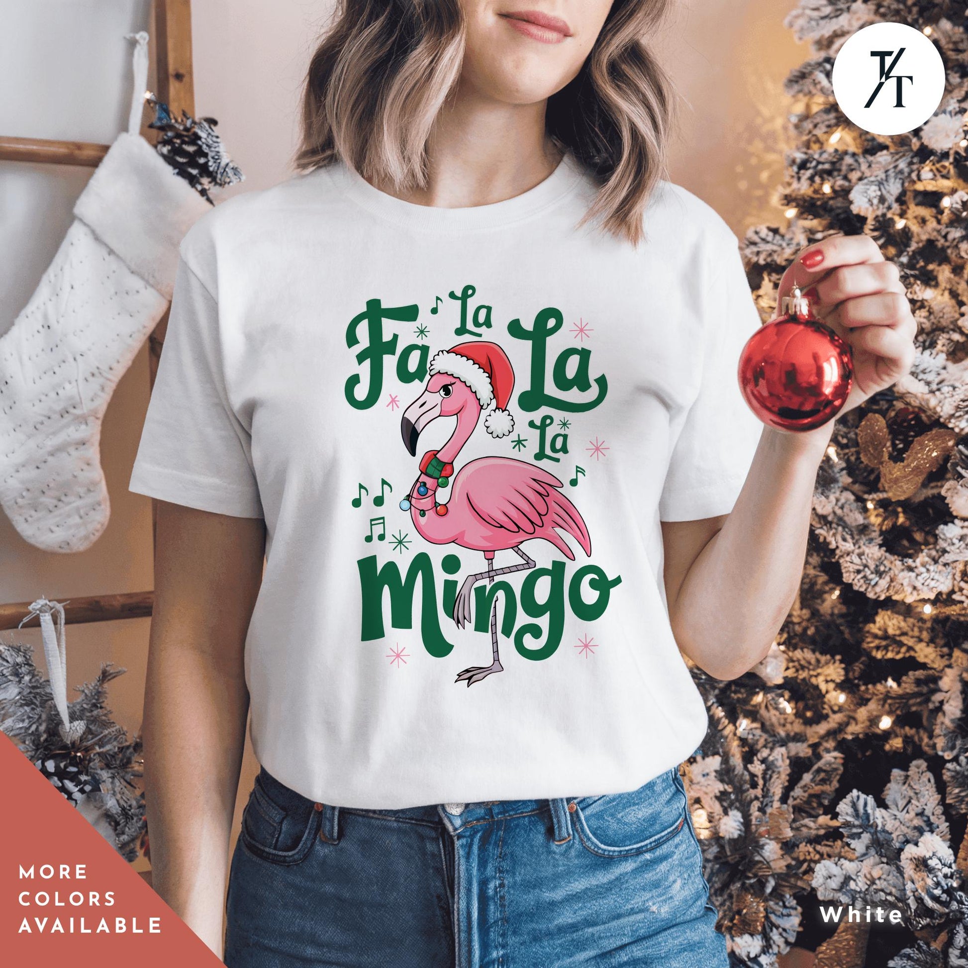 a woman holding a christmas ornament in front of a christmas tree