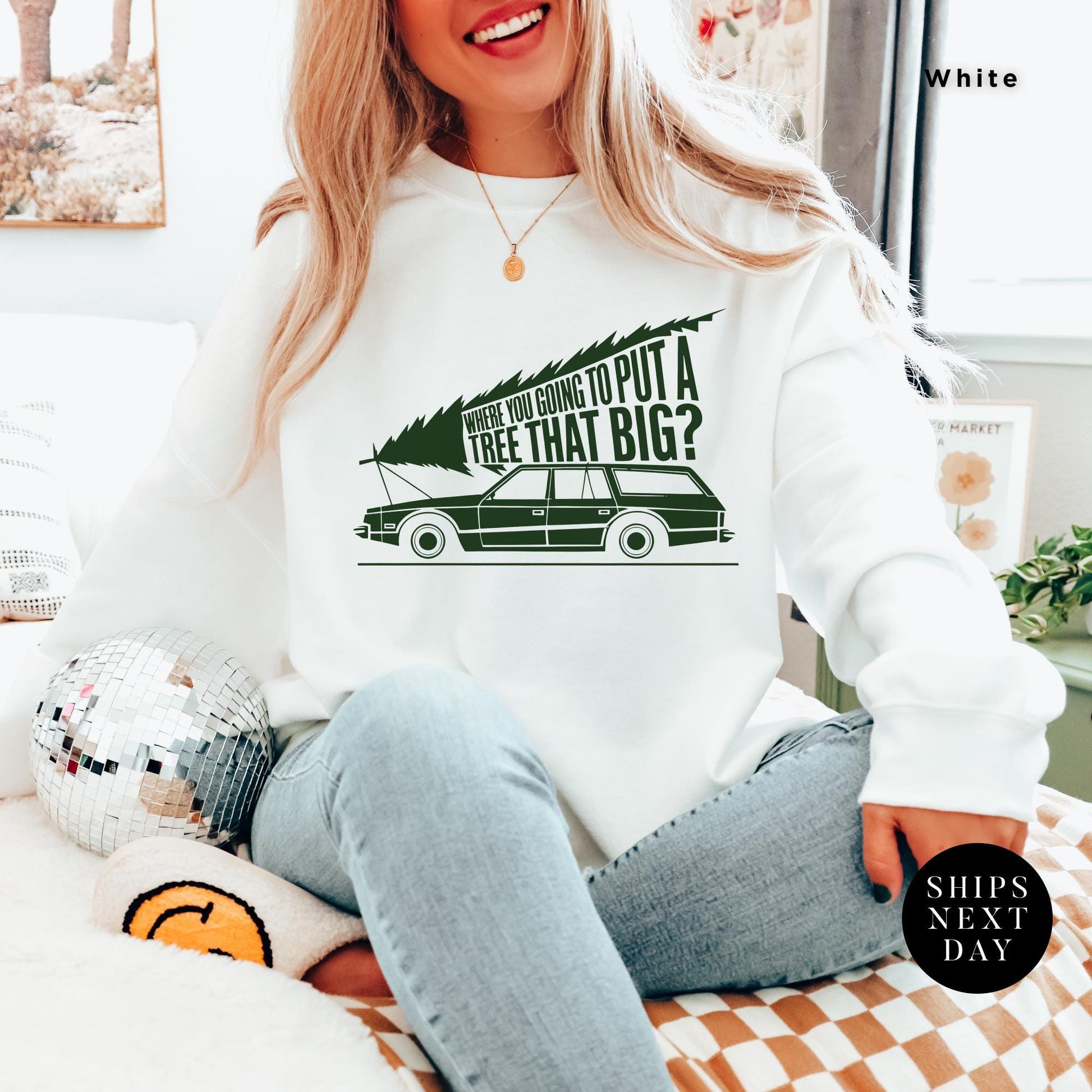 a woman sitting on a bed wearing a white sweatshirt, You&#39;Re Gonna Put A Tree That Big Unisex Sweatshirts, Funny Christmas Gift, Griswold Sweatshirt, Christmas Sweatshirts for Christmas Vacation